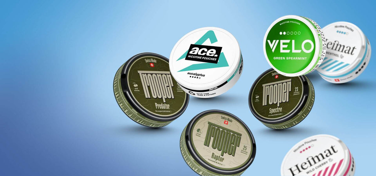 Selezione di Snus e Nicotine Pouches: Nоoper, Velo Green Spearmint e Heimat lattine su sfondo blu